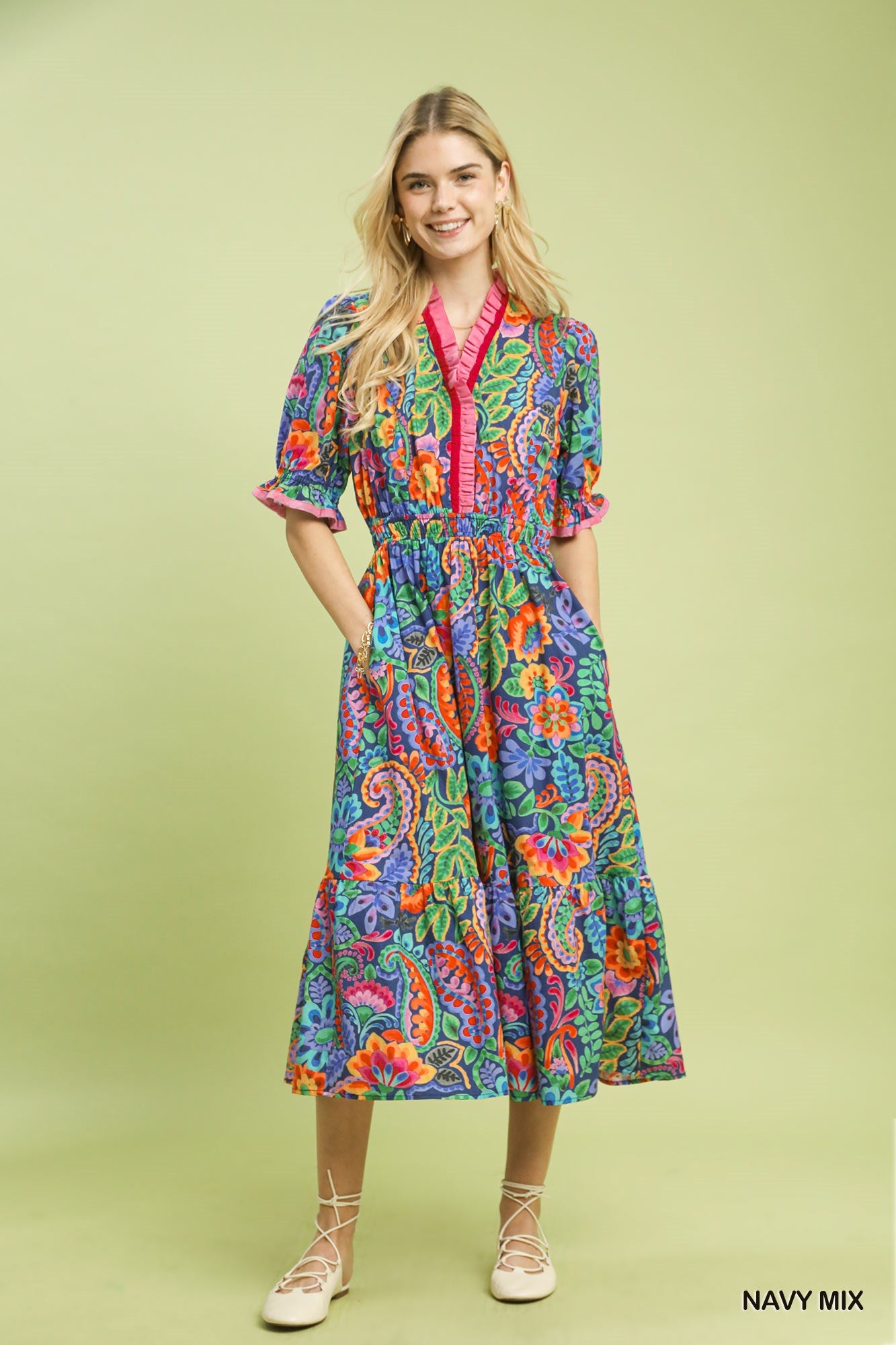 model wearing a navy floral dress with tan background