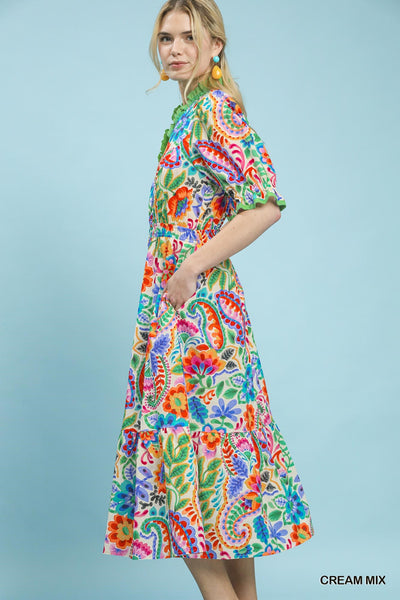 model wearing a cream floral dress with a mint background
