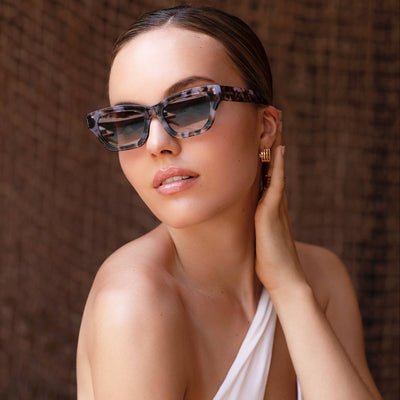 Woman wearing sunglasses with a neutral background