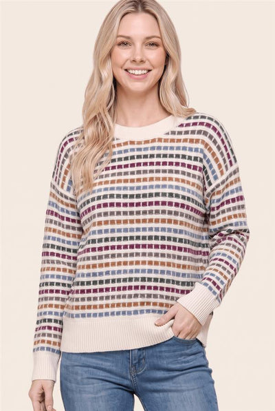 woman wearing a cream and multi color striped sweater and jeans