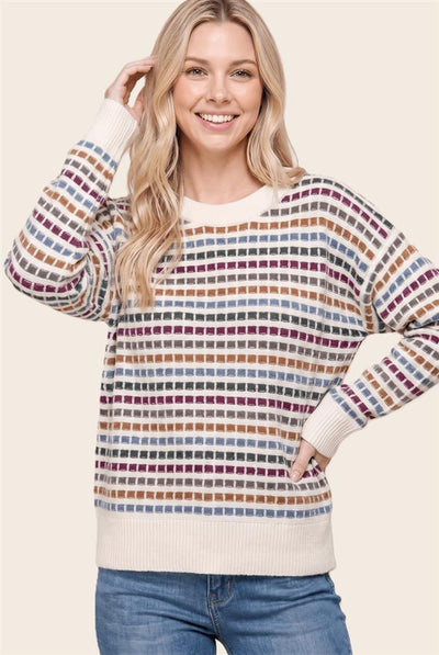 woman wearing a cream and multi color striped sweater and jeans