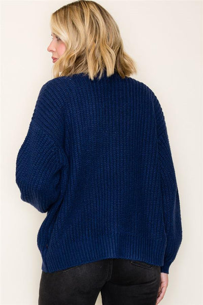 Person wearing a blue sweater against a white background