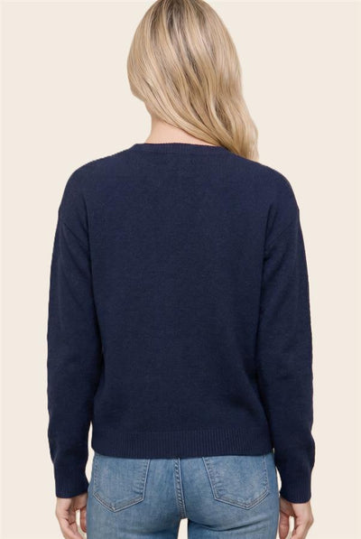 back of a model wearing blue jeans with a navy cardigan