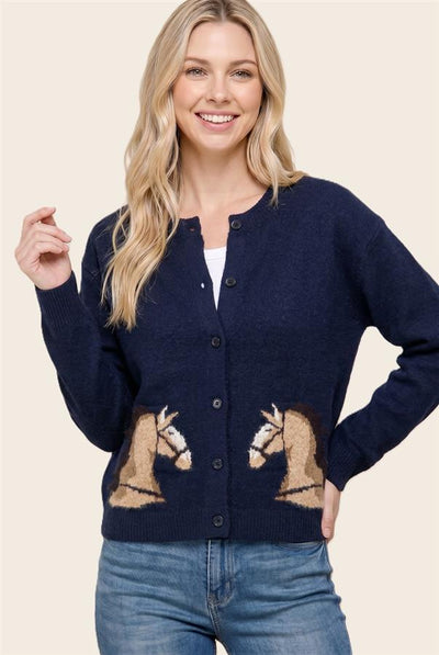 model wearing a white shirt and blue jeans with a navy horse themed cardigan buttoned up