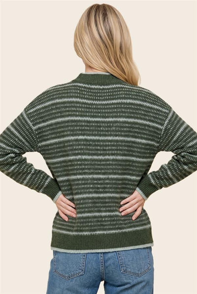 A woman shown from the back wearing a dark green and gray striped knit sweater with blue jeans, set against a solid light beige background.