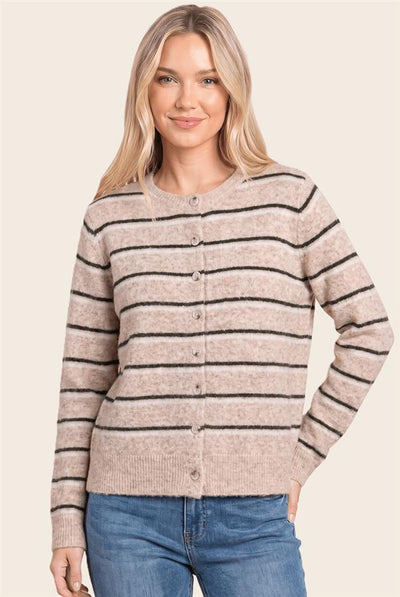 A woman modeling a beige cardigan sweater with thin black horizontal stripes and a button-up front, paired with blue jeans against a solid light beige background.