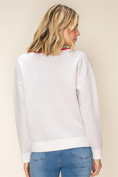 A woman shown from the back wearing a light gray crewneck sweatshirt with a red and green striped collar trim, paired with blue jeans, against a solid beige background.