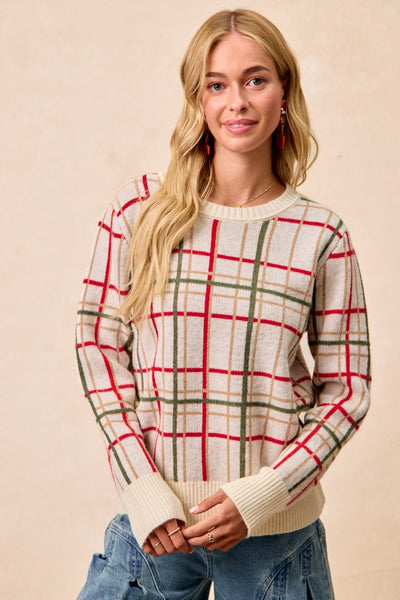 Woman wearing a plaid sweater with a beige background