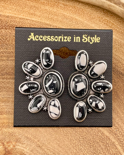 black & white earrings on a wooden background