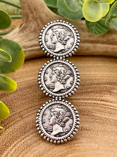 Three stacked silver coin-style ring on a wooden background.