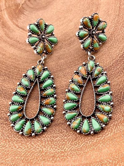 green earrings on a wooden background