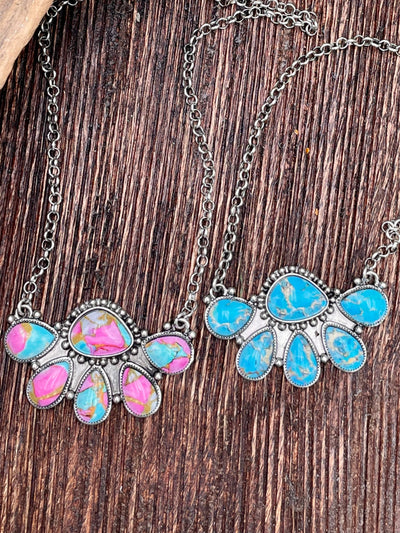 Two necklaces with colorful stones on a wooden surface