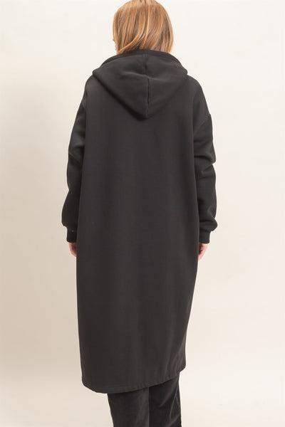 back of model wearing a long black coat with a hood