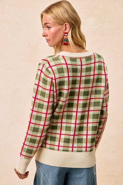 Woman wearing a plaid sweater with a beige background