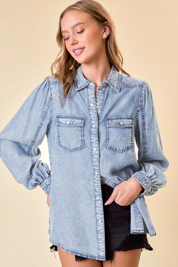 model wearing a long sleeve denim top & cutoff shorts on tan background