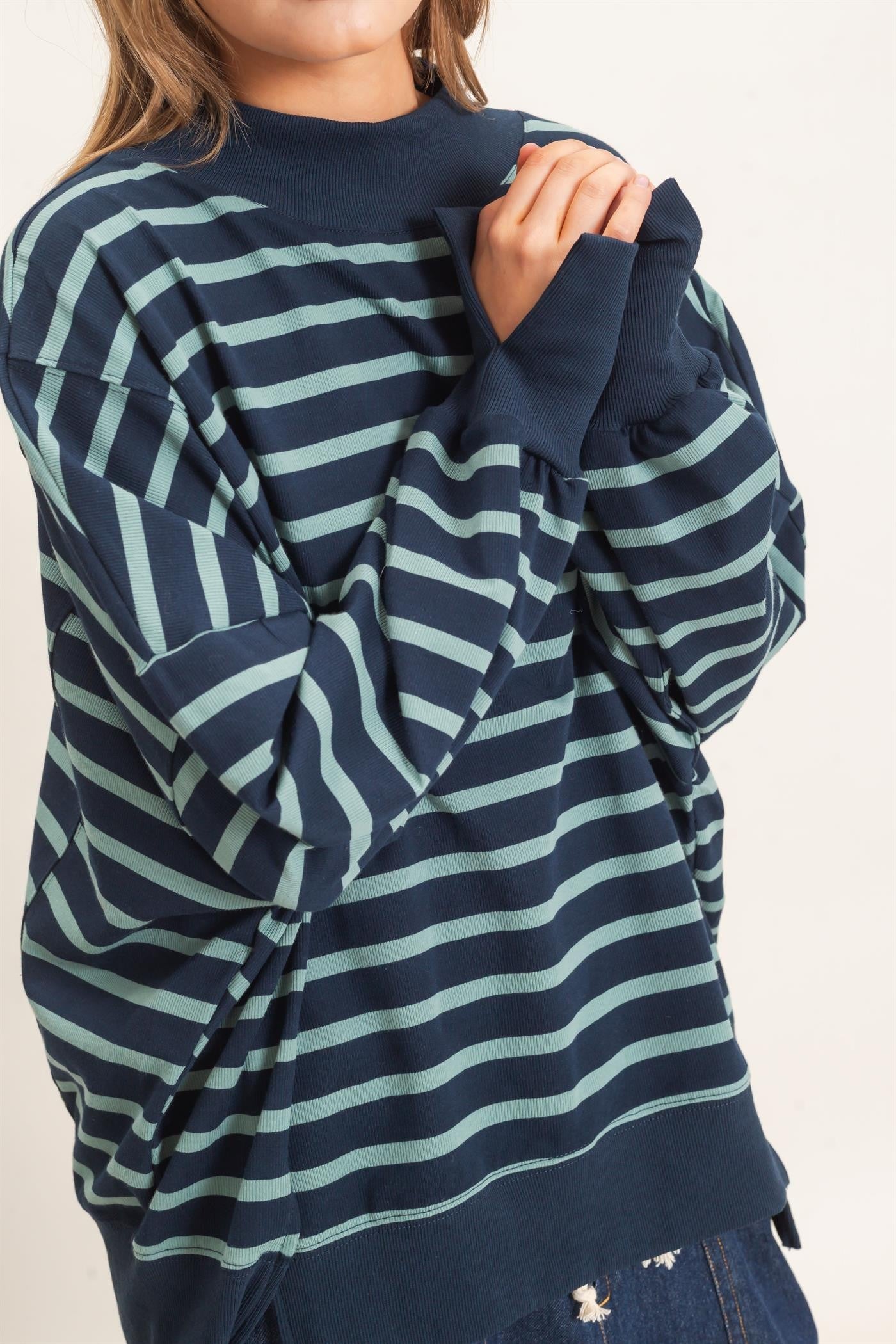 woman wearing a navy/sage striped sweatshirt