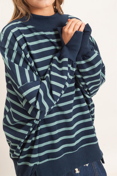 woman wearing a navy/sage striped sweatshirt