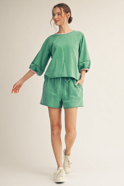 model wearing a green top & shorts