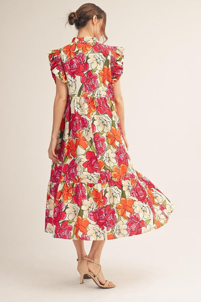 back of model wearing a a pink & orange floral dress with a light background