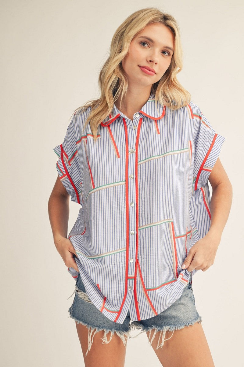 model wearing geometric print top with cutoff denim shorts