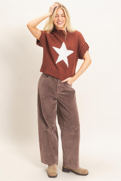 model wearing a short sleeve star sweater with charcoal pants