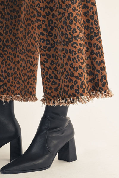 close up of raw hem and black boots on leopard pants