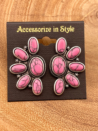 pink earrings on a wooden background