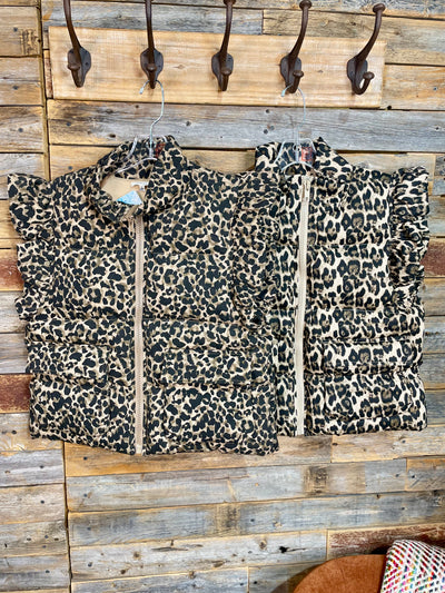 Leopard print jacket on a wooden background with hooks