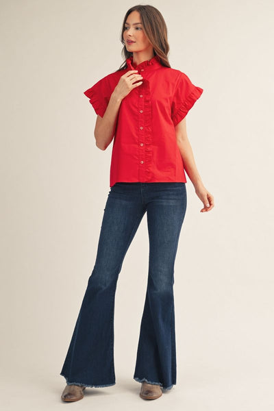 Woman wearing a red blouse and blue jeans on a beige background