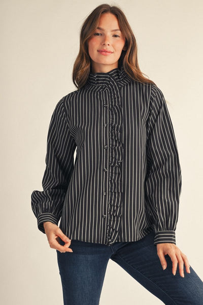 model wearing a black & white striped blouse & jeans in front of a beige background