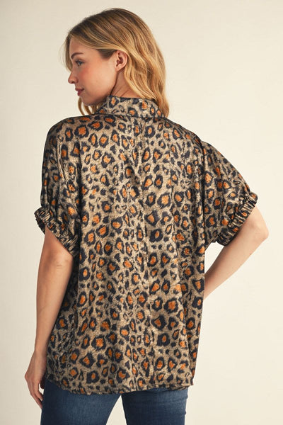 Woman wearing a leopard print shirt with short sleeves on a beige background
