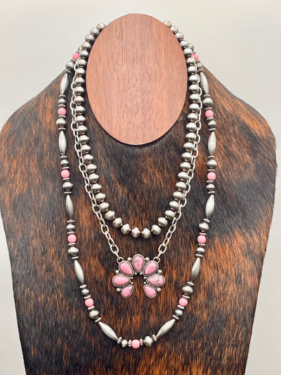 Necklace with pink pendant on a wooden mannequin