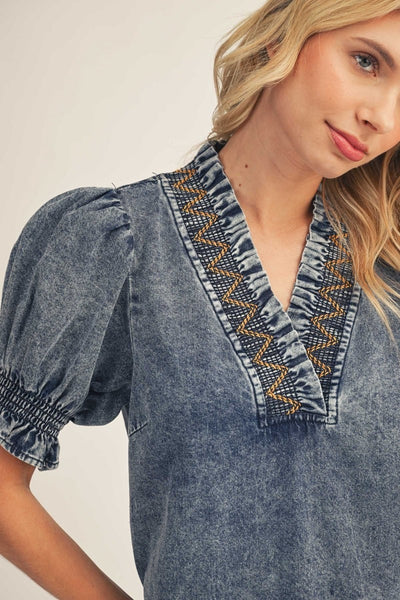 model wearing denim dress with tan background