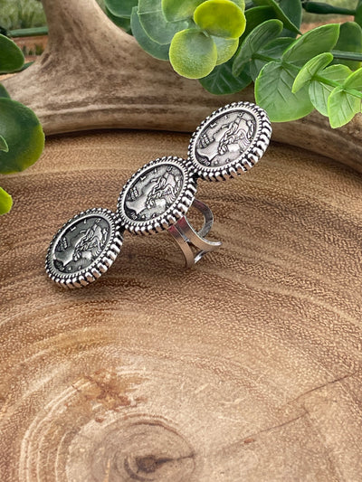 side view of a triple stacked silver coin-style ring on a wooden background.