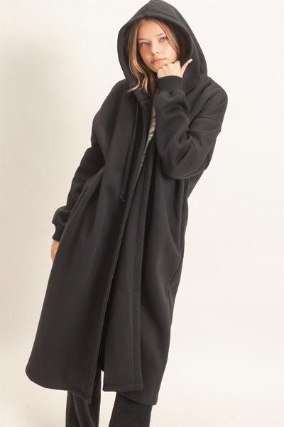 model wearing a long black coat with a hood