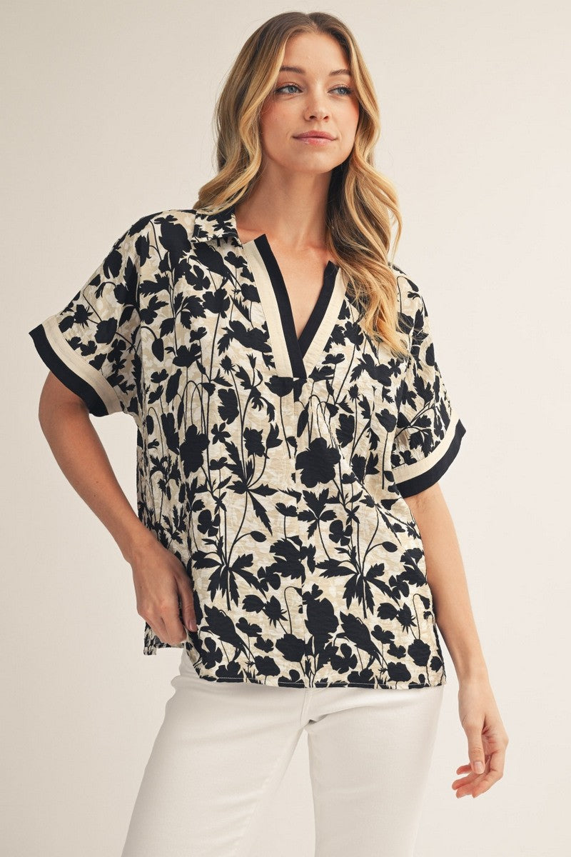 model wearing floral top & white pants