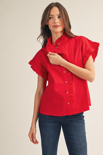 Woman wearing a red blouse with ruffled sleeves on a beige background