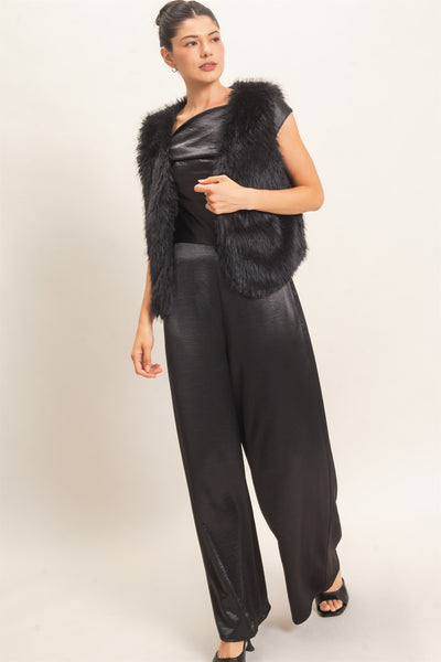 model wearing a black satin outfit & black faux fur vest with a light background