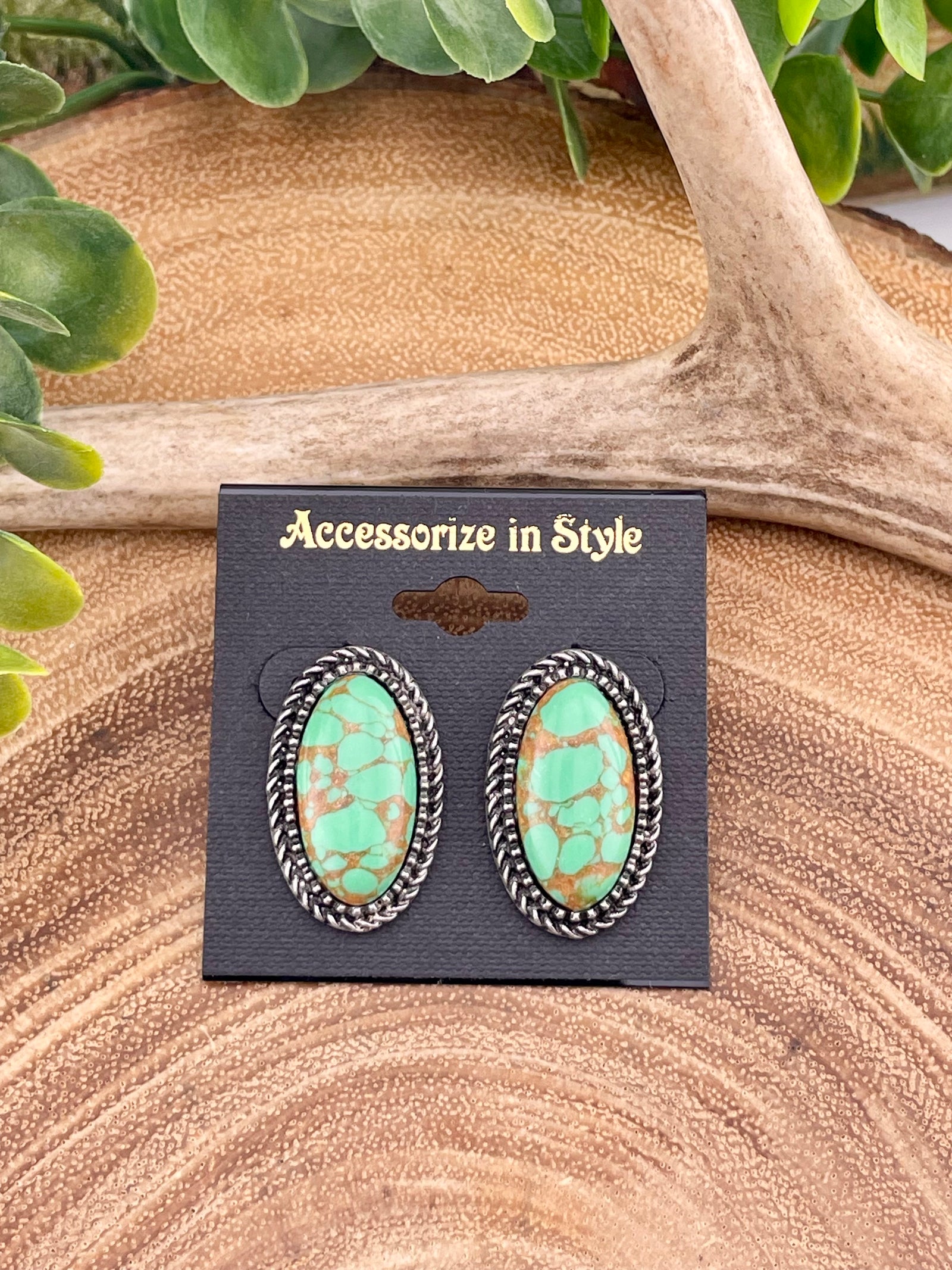 oval green earrings on a wooden background