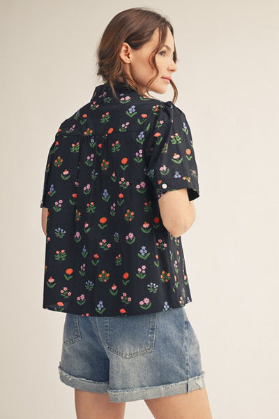 model wearing black floral top & cuffed denim shorts