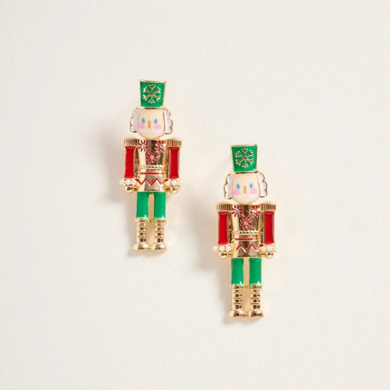 Nutcracker-shaped earrings on a light beige background