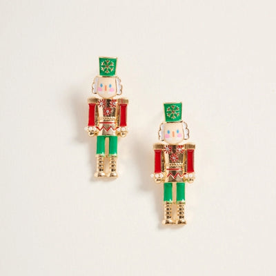 Nutcracker-shaped earrings on a light beige background