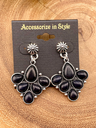 Pair of black teardrop earrings on a 'Accessorize in Style' card against a brown background