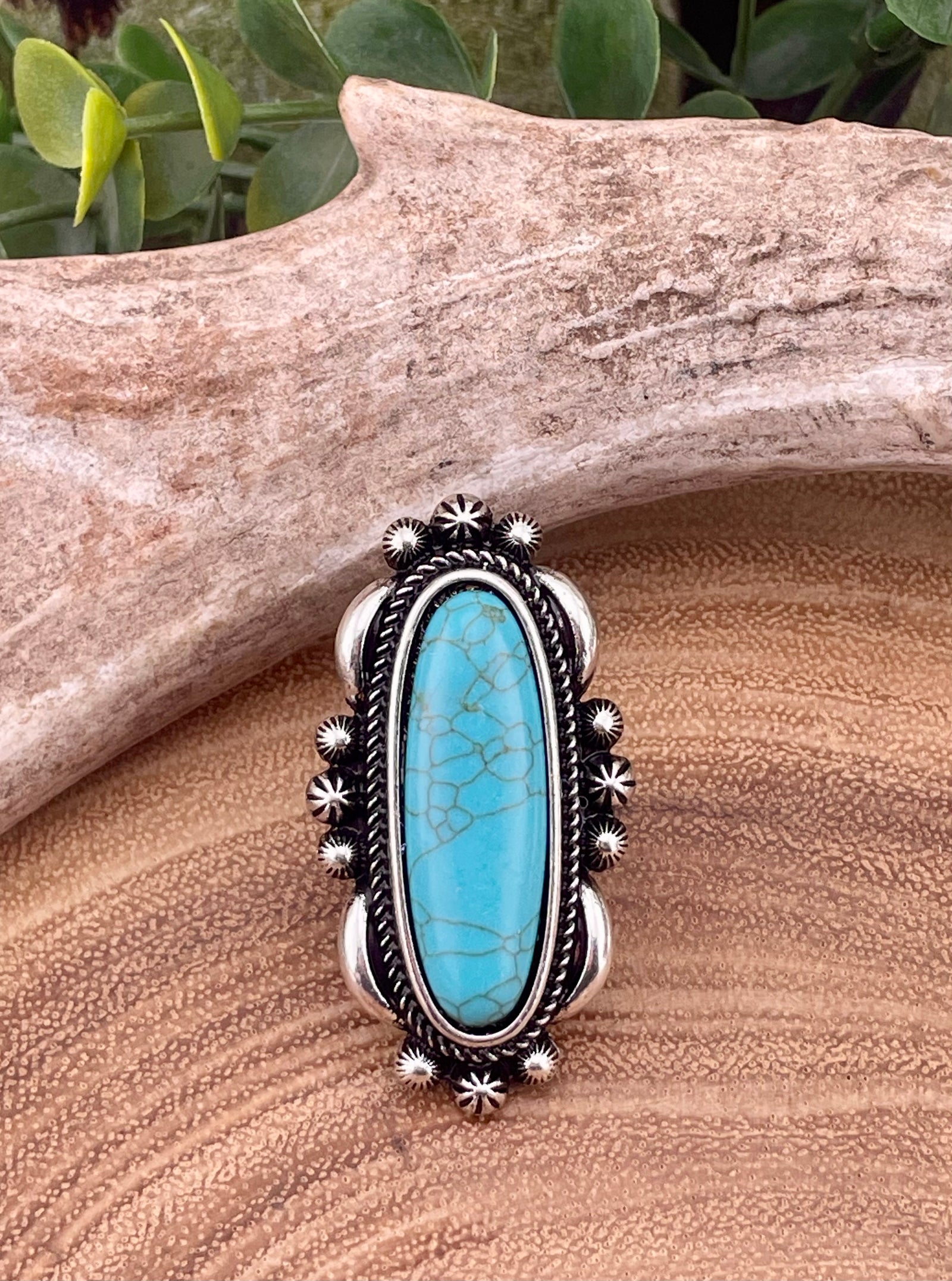Silver ring with turquoise stone on a wooden surface