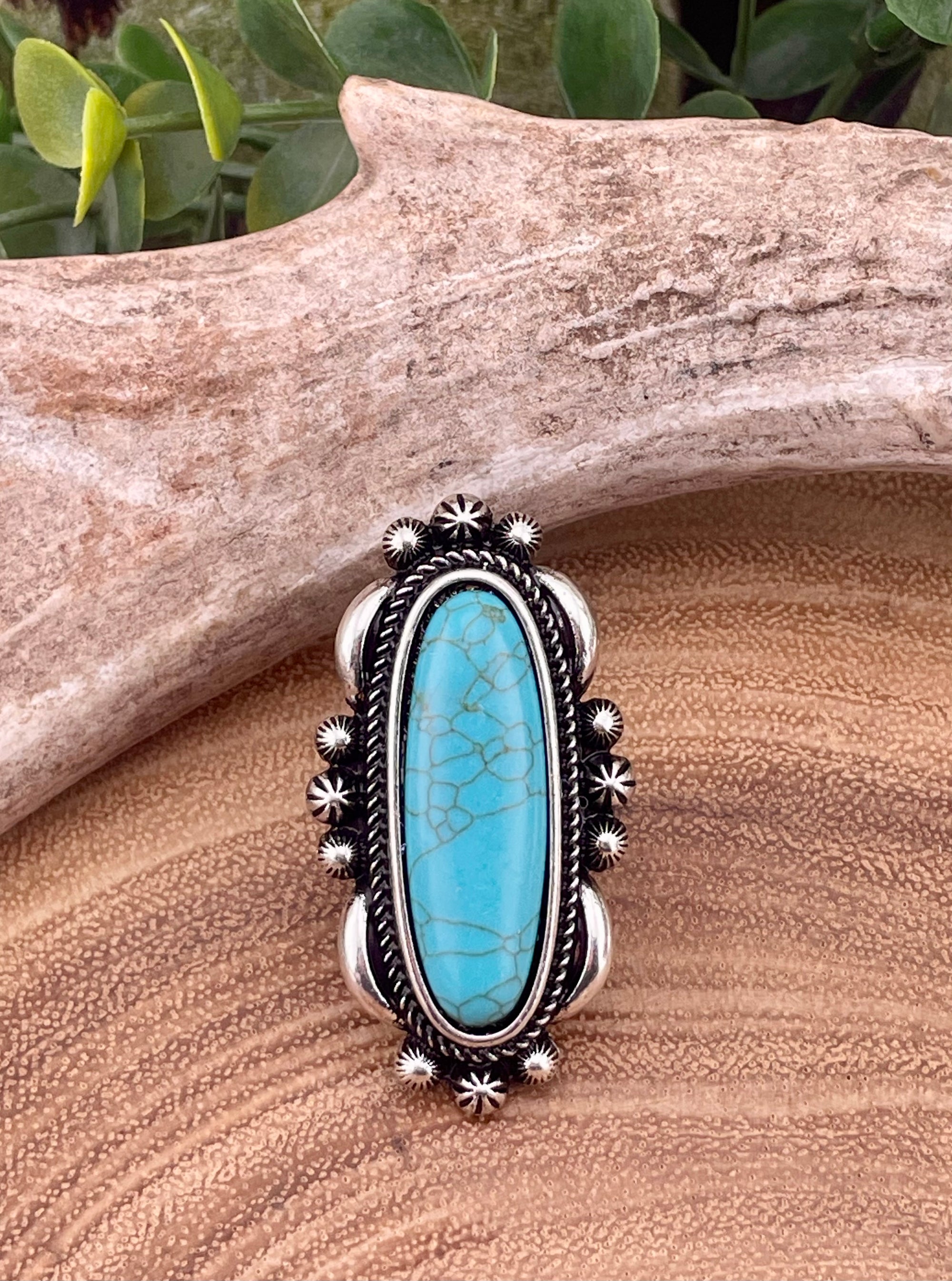Silver ring with turquoise stone on a wooden surface