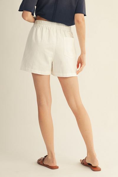 model wearing white drawstring shorts