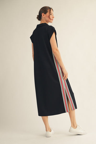 back of model wearing a black dress with stripes along the sides & neckline.