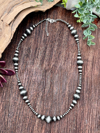 Necklace with silver beads on a wooden surface
