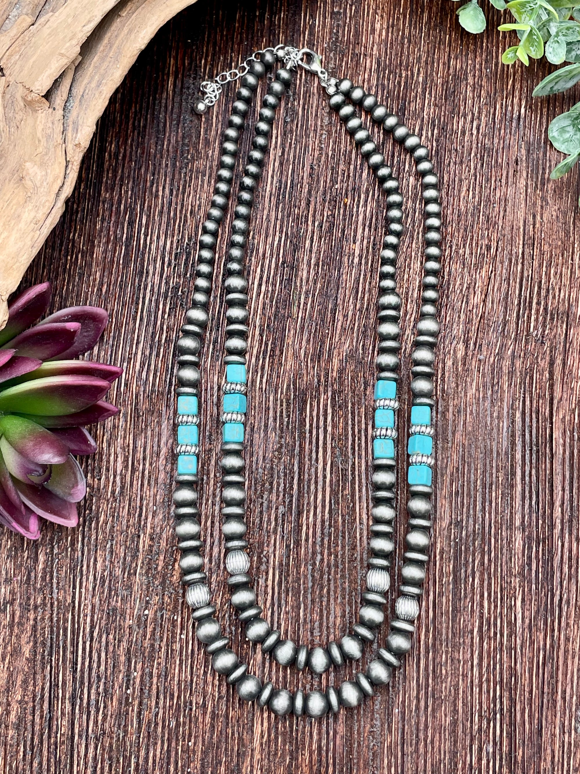 Necklace with silver and turquoise beads on a wooden surface