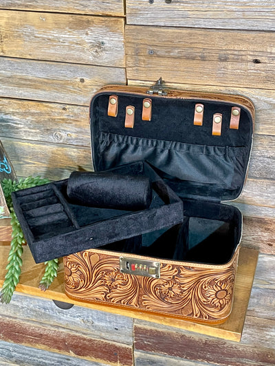 Open jewelry box with intricate designs on a wooden surface